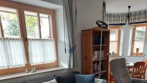 A living room with a dark grey sofa, a wooden coffee table, and a bookshelf.