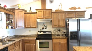 A kitchen with wooden cabinets, stainless steel appliances, and a granite countertop.