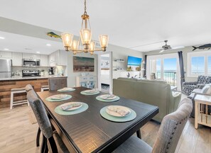 Une cuisine moderne avec un coin repas, un ventilateur de plafond et une vue sur l’extérieur.