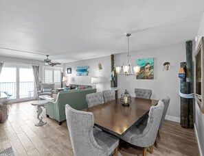 A spacious dining area with a large wooden table and grey upholstered chairs. - 404-mWelcome to Paradise beautifully remodeled Beachfront condo (Destin)