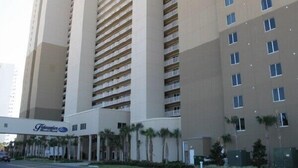 A tall hotel with multiple floors, featuring a central atrium with a staircase.