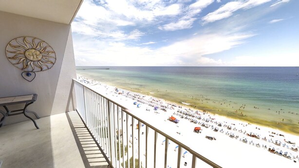 A balcony with a view of a beach and pier.