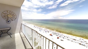 Un balcon avec vue sur une plage et une jetée.