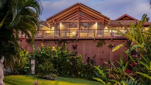 A large, modern house with a spacious deck and a well-maintained garden.