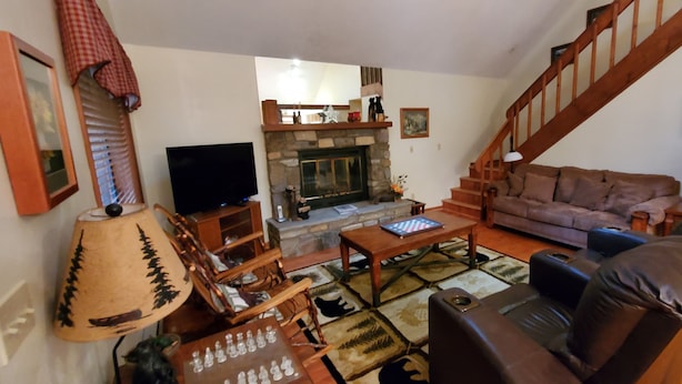 A living room with a fireplace, a sofa, a coffee table, and a television. - 3 Bedroom 2 bath Home, Easy Access, Covered Porch, Diligent Views & Internet (Maggie Valley)