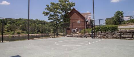 Una cancha de baloncesto al aire libre con un edificio de madera al fondo.