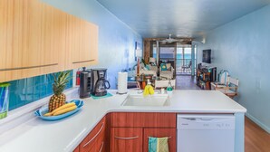A modern kitchen with wooden cabinets, a white countertop, and a built-in dishwasher. - Kona Bali Kai 317 Direct Oceanfront, Major Upgrade with Central Air. (Kailua Kona)