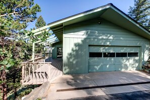 A single-story building with a garage, a covered porch, and a stone retaining wall.