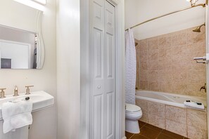 Ein Badezimmer mit einem weißen Waschbecken, einer Toilette und einer Badewanne.