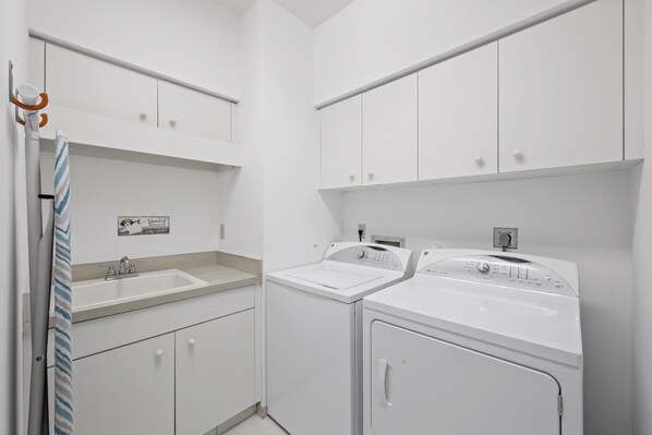 Un baño moderno con lavamanos, espejo y dos lavadoras.