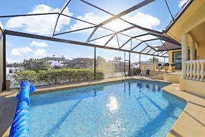 A pool area with a clear view of the sky and surrounding houses.
