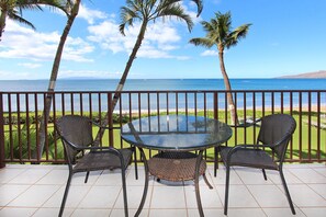 Enjoy ocean views from this balcony with a glass-top table and two wicker chairs.