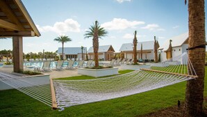 A pool area with lounge chairs and a hammock. - Luxurious Townhouse on 30a! 6-Seat LSV, Beach, Pool, Walk to Shopping+Dining. (Panama City)