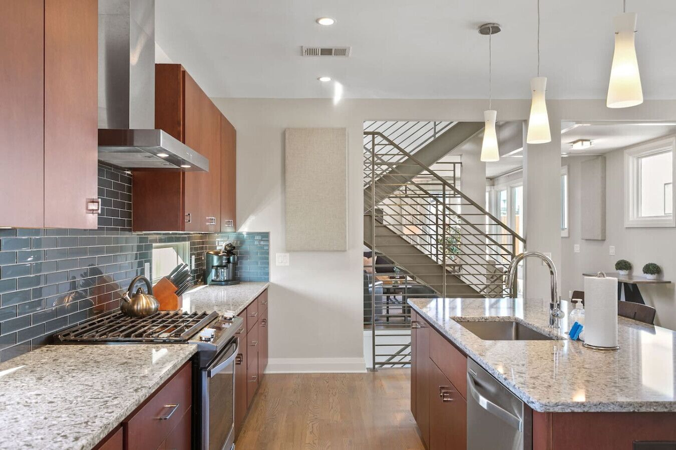 A modern kitchen with granite countertops, stainless steel appliances, and a central island.