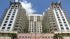 Un edificio de gran altura con varios pisos, balcones y un patio central.
