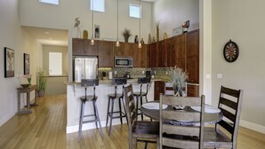 A spacious kitchen with wooden cabinets, a central island, and bar stools.