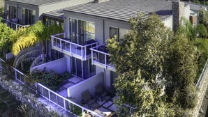 A modern house with a flat roof, large windows, and a balcony.