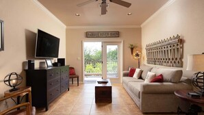 Ein Wohnzimmer mit Fernseher, einer Couch, einem Couchtisch, einem Kamin und einem Schild mit der Aufschrift 'Parker River Haus'.