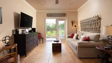 A living room with a television, a sofa, a coffee table, a fireplace, and a sign reading 'Parker River Haus'.