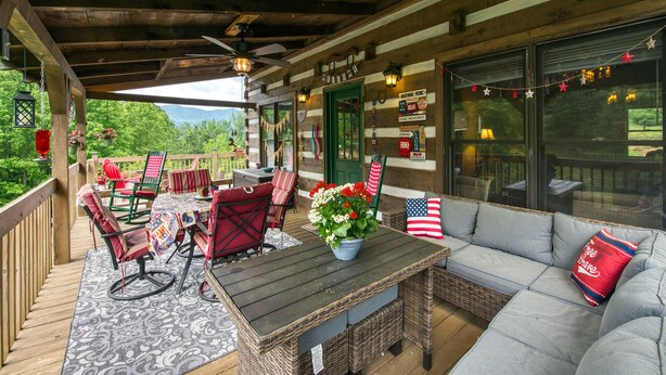 Un espace extérieur aménagé avec des meubles en osier, une table et une vue sur les montagnes.