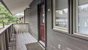 A wooden porch with a red door and large windows. - Newly Renovated 4BR / 4BA Pet-Friendly, Best Walking Location At Boyne Mountain (Boyne Falls)