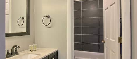 Une salle de bain avec un lavabo, un miroir et des toilettes.