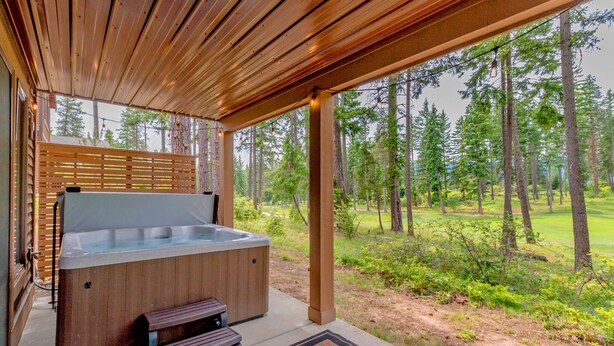 A hot tub under a wooden pergola with a view of a forested area. - Walk to the Winery! On the Golf Course in Suncadia! Hot Tub | Up to 33% Off!! (Cle Elum)