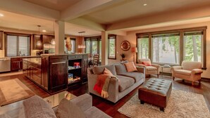 A spacious living area with a large sofa, a dining table, and a kitchen in the background. - Walk to the Winery! On the Golf Course in Suncadia! Hot Tub | Up to 33% Off!! (Cle Elum)