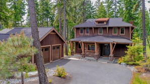 A two-story log cabin with a stone foundation and a covered porch. - Walk to the Winery! On the Golf Course in Suncadia! Hot Tub | Up to 33% Off!! (Cle Elum)