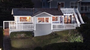 A two-story house with a balcony, a staircase, and a sign indicating it is for vacation rental.