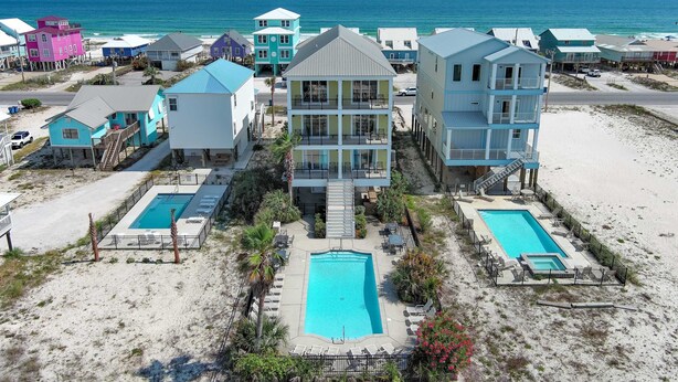 A beachfront property with multiple buildings, a central pool, and a smaller pool. - Dream Big by GSVR | Beachview Family Reunion Home w/ Big Pool & Elevator + FREE Activities/Golf (Gulf Shores)