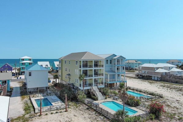 A beachfront hotel with multiple buildings, a pool area, and a beach view.