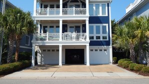 Ein zweistöckiges Wohnhaus mit Veranda, Garage und Balkon.