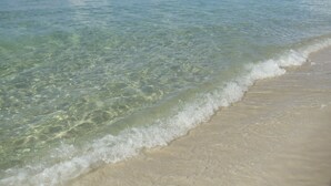 Una playa con agua cristalina y una orilla arenosa.