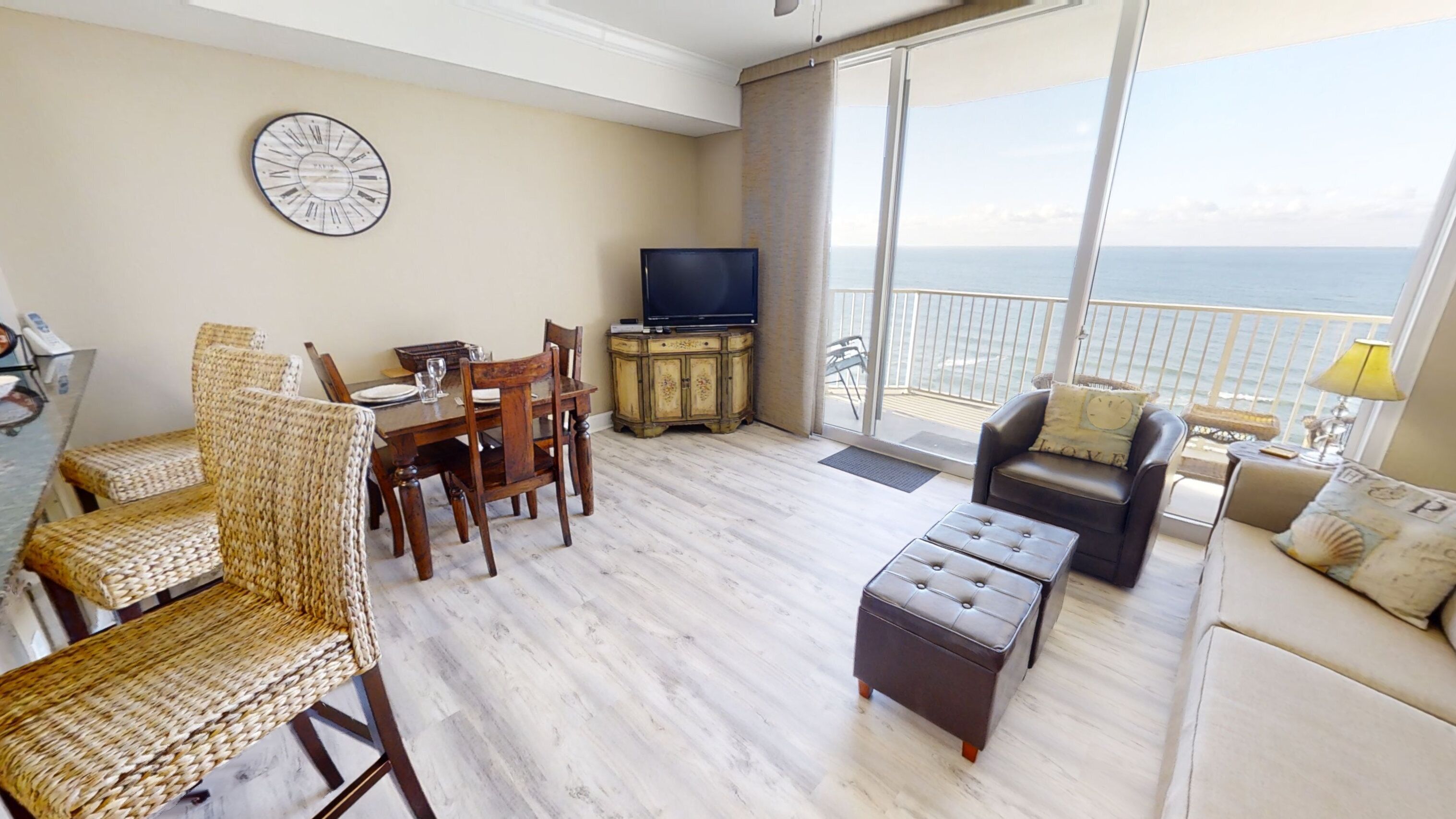 Un espacio habitable amplio con balcón con vistas al mar, un comedor y un televisor.