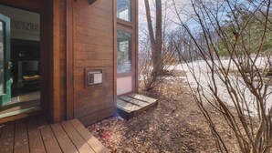 Une cabane en bois avec une entrée bien visible et un petit espace porche.