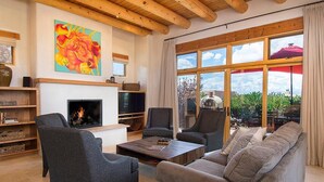 A living room with a fireplace, sofas, armchairs, and a TV. - Hacienda Artist Paradise (Santa Fe)