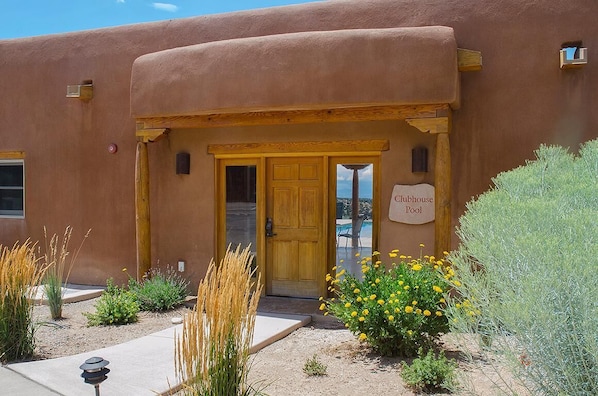A building with a sign reading 'Clubhouse Pool' and a wooden door.