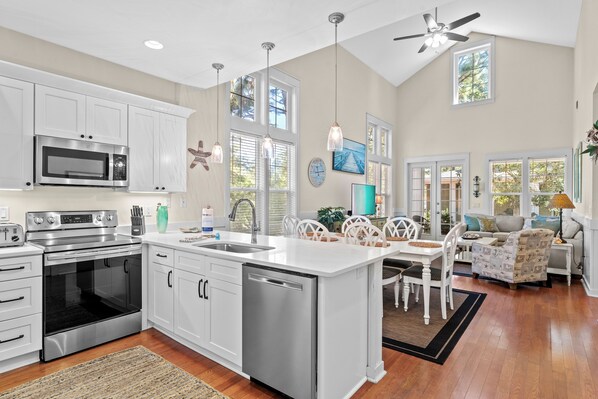 A spacious kitchen with white cabinetry, stainless steel appliances, and a large island.