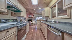 A kitchen with wooden cabinets, a stainless steel stove, and a large window.