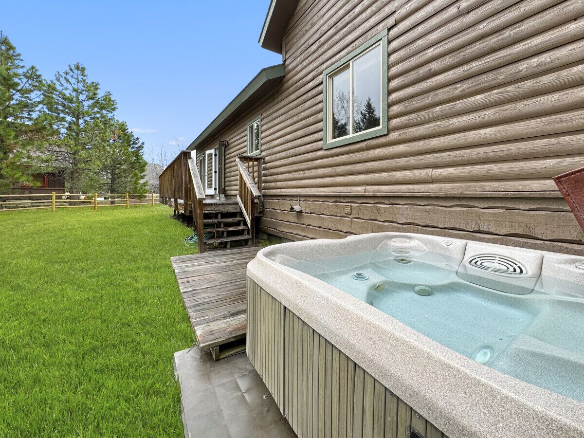 Une cabane en bois avec un jacuzzi et une terrasse en bois.
