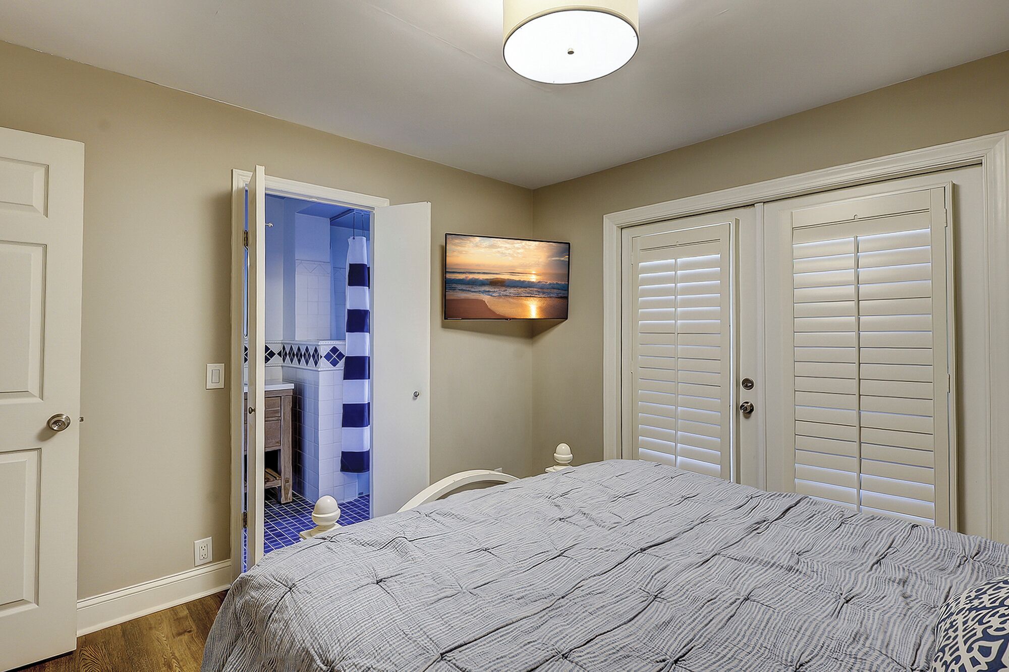 A bedroom with a bed, a shower, and two closets.