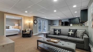 Une chambre d’hôtel moderne comprenant un lit, un canapé, une table basse et un coin repas.