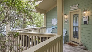 A porch with a clock, a sign reading "Elijah Cottage," and a door with a glass panel. - Gated Resort ~ Golf Cart ~ Outdoor Deck (Miramar Beach)