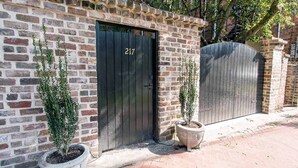 A brick building with a black door marked "217" and a gated entrance.