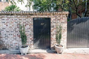 Stylish entrance to a residence with a black door and potted plants.
