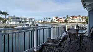 Ein Balkon mit Blick auf eine Marina, ein angedocktes Boot und Gebäude im Hintergrund.