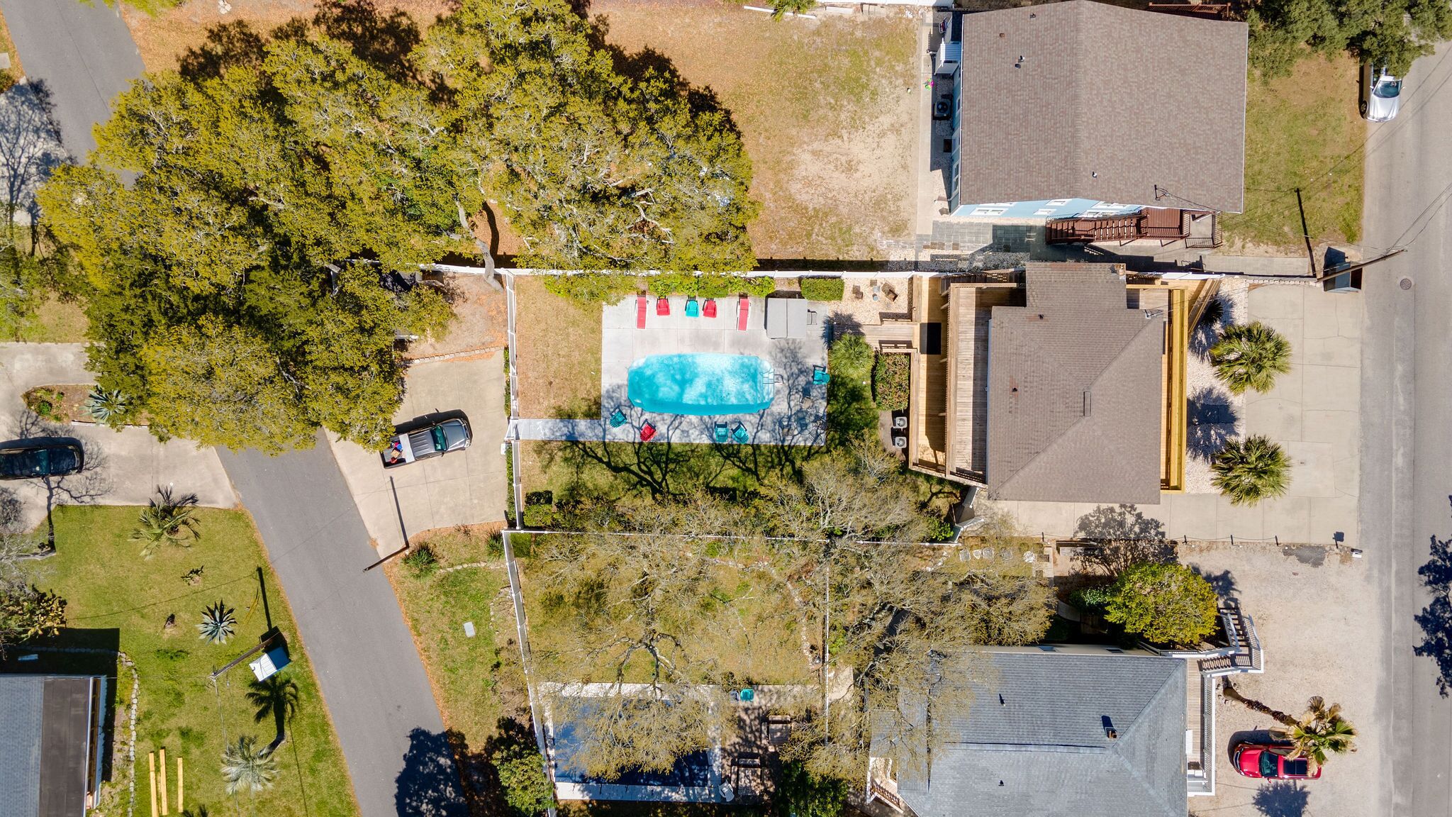 Vue aérienne d’une propriété dotée d’une piscine, d’un patio couvert et d’un espace de stationnement.