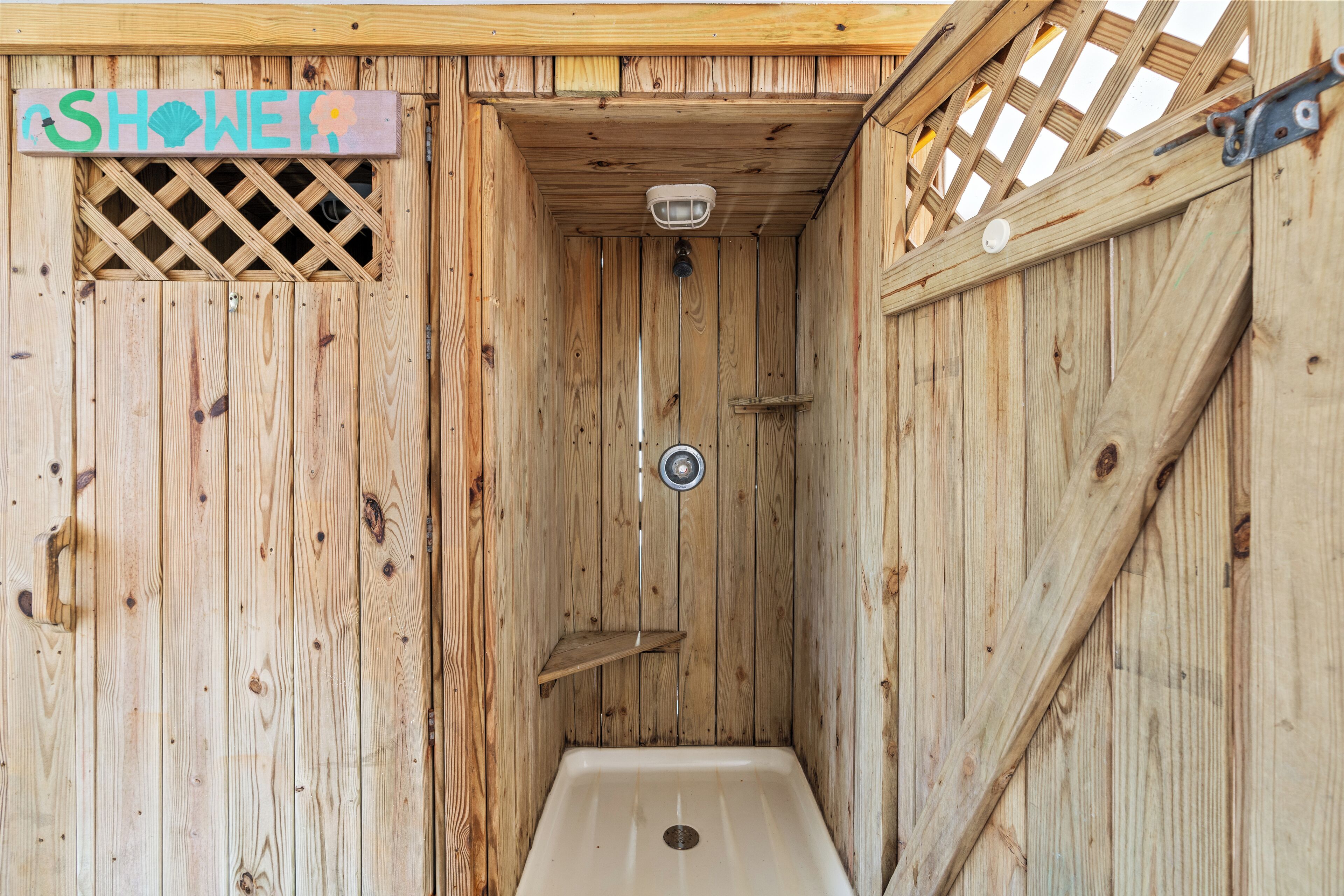 A wooden shower stall with a "SHOWER" sign above it.