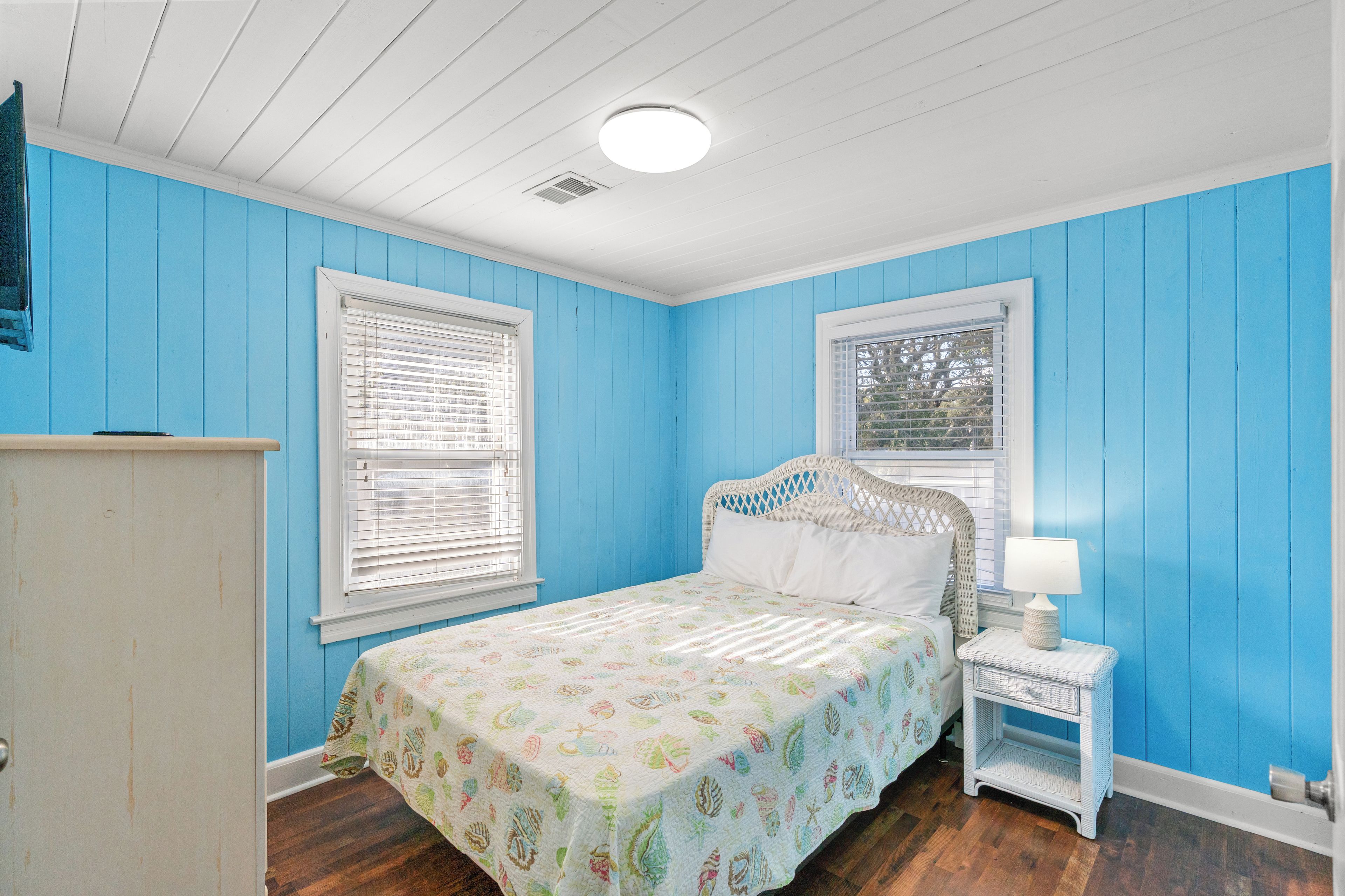 Une chambre à coucher avec un lit, une table de chevet et une commode.